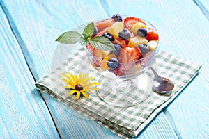 Salad with strawberries and blueberries and apricots on the napkin.