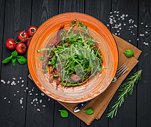 Salad with sun-dried tomatoes, arugula and herbs