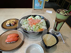 salad, sushi, avocado juice and mayonaise are delicious combination menu with fish salmon, rice and vegetable topping