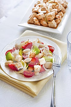 Salad with three kinds of tomatoes, boiled white kidney beans and croutons from white bread