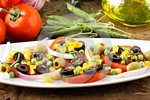 Salad of tomato, olives, corn and peas