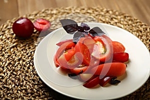 Salad of tomato and red plums with basil for a healthy diet