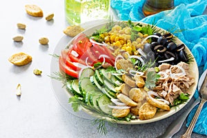 Salad with tuna, fresh tomato, cucumber, onion, pickled olives, corn and salad dressing vinaigrette