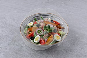 salad with tuna, quail eggs and baked potatoes on a stone background, studio food photography 1