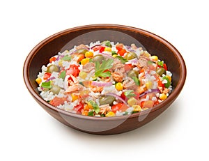 Salad of tuna, rice and vegetables in a terracotta salad bowl isolated on a white background.