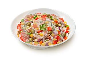 Salad of tuna, rice and vegetables in a white porcelain salad bowl isolated on a white background.