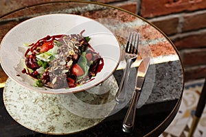 Salad with veal and tomatoes. Beef steak with raw vegetables mix side view. Grilled meat with garnish close-up