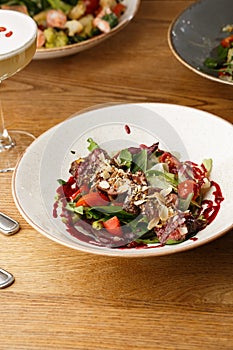 Salad with veal and tomatoes. Beef steak with raw vegetables mix side view. Grilled meat with garnish close-up