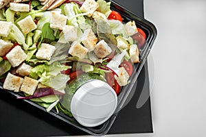 Salad with vegetables and chicken and pesto sauce in lunch box. The concept of food and food delivery