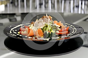 salad of vegetables,lechuga with mayonnaise,sliced meats of ham and jamon beautifully decorated with chopped vegetables on a plate photo