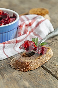 Salad vinaigrette and a portion on a fork on a wooden background