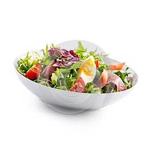 Salad on White. a bowl of fresh lettuce salad with tomatoes eggs prosciutto over white