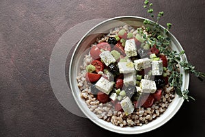 Salad of whole grain cereal spelt with feta cheese, cherry tomatoes and oregano.