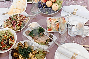Salads and snacks in the assortment on the festive table.