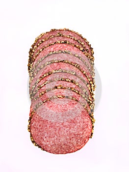 Salami with black pepper, in slices, isolated. Meat cold cuts on white background. Packshot photo for package design.