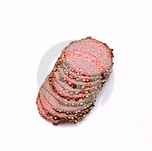 Salami with black pepper, in slices, isolated. Meat cold cuts on white background. Packshot photo for package design.