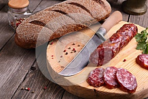 Salami, bread and a knife on the table