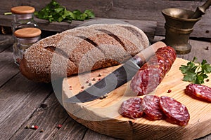 Salami, bread and a knife on the table