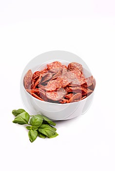 Salami chips, meat snacks in a bowl, isolated. Salami slices, close-up. Packshot photo for package design.