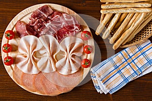 Salami cutting board breadsticks and napkin