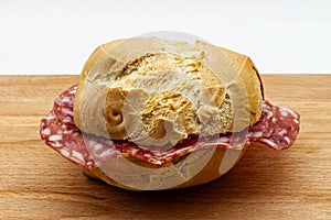 Salami sandwich. Panino al salame on wooden table