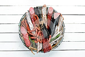 Salami, sausages, spices and meat products in a wooden box. Top view.