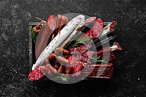 Salami, sausages, spices and meat products in a wooden box. Top view.