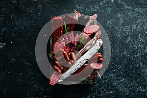 Salami, sausages, spices and meat products in a wooden box. Top view.