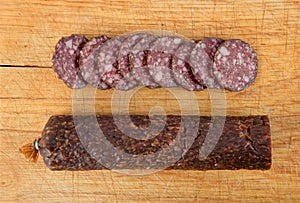 Salami sliced on wooden board