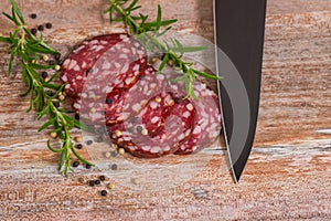 Salami slices with pepper and rosemary