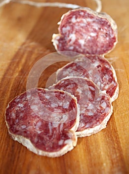 Salami slices on wood trencher