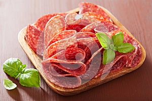 Salami slices in wooden plate