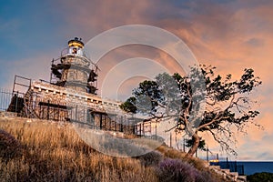 Salamis island, Greece. The stone built lighthouse at cape Koghi in Salamis island on sunet with colorful sky