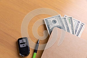 Salary in the envelope with car key on the table