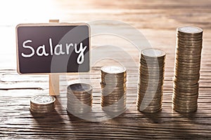 Salary Text On Small Chalk Board With Coin Stack photo