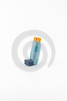 Salbutamol inhaler with cigarettes on white background photo