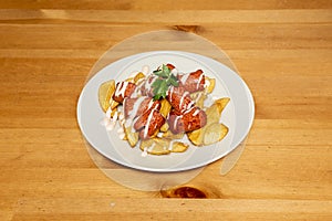 Salchipapa is a fast food consisting of fried slices of sausage and French fries, consumed as street food photo