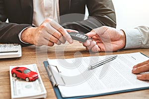 Sale agent giving Car key to customer and sign agreement contract, Insurance car concept