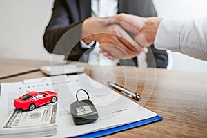 Sale agent handshake deal to agreement successful car loan contract with customer and sign agreement contract  Insurance car