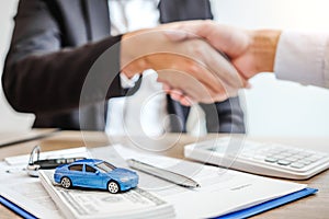 Sale agent handshake deal to agreement successful car loan contract with customer and sign agreement contract  Insurance car