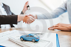 Sale agent handshake deal to agreement successful car loan contract with customer and sign agreement contract  Insurance car