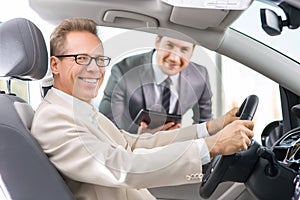 Sale assistant showing car to customer