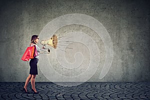 Sale concept, stylish young woman shouting in megaphone