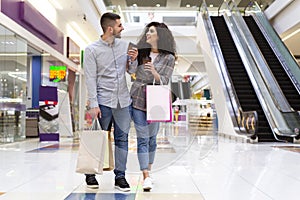 Sale And Consumerism Concept. Happy Couple Walking In Mall