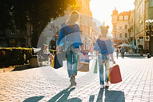 Sale, consumerism, money and people concept - happy young woman with shopping bags and credit card in mall