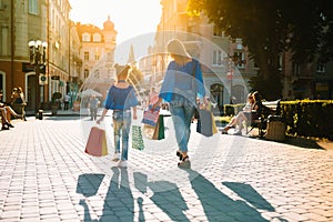 Sale, consumerism, money and people concept - happy young woman with shopping bags and credit card in mall