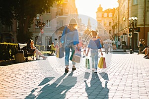 Sale, consumerism, money and people concept - happy young woman with shopping bags and credit card in mall