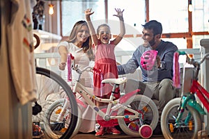 Sale, consumerism and people concept - happy family with child and shopping new bicycle photo