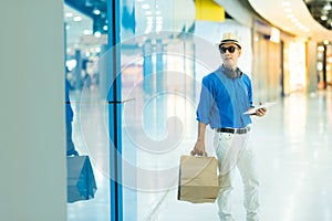 Sale, consumerism and people concept - happy young asian man wit