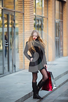 Sale, consumerism and people concept - happy young beautiful women holding shopping bags, walking away from shop.